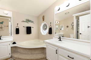 Full bathroom featuring a garden tub and two vanities