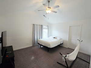Bedroom featuring dark colored carpet, ceiling fan, and high vaulted ceiling