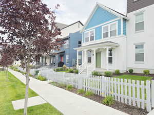 View of front of home featuring a fenced front yard, stucco siding, covered porch, and a residential view
