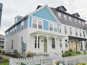 View of front of home with a fenced front yard, a porch, and stucco siding