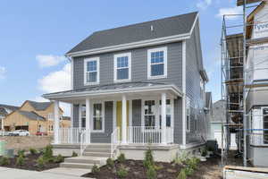 View of front of home with covered porch, a standing seam roof, a metal roof, and roof with shingles
