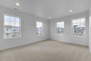 Unfurnished room with light carpet, recessed lighting, and plenty of natural light