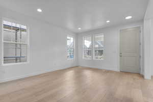 Empty room featuring light wood-type flooring and recessed lighting