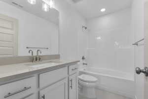 Bathroom featuring shower / bathtub combination, vanity, and light tile patterned floors