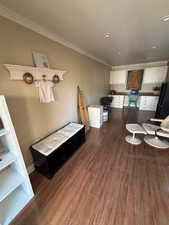 Interior space with dark wood-type flooring, crown molding, recessed lighting, and a desk