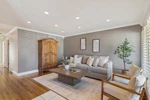 Living room with crown molding, recessed lighting, and wood finished floors