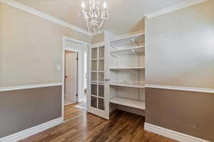 Walk in closet with dark wood-style floors and a chandelier