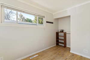 Spare room with light wood finished floors and crown molding