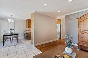 Living room with crown molding, light wood-style floors, a chandelier, and recessed lighting