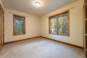 Unfurnished bedroom with light colored carpet and a closet
