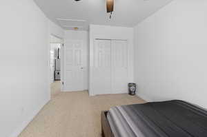 Bedroom featuring a closet, light carpet, and ceiling fan