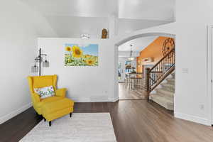 Living area ,arched walkways, dark wood-style floors, and vaulted ceiling