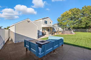 Rear view of house with a patio, a fenced backyard, and a fire pit