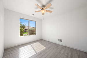 Spare room featuring light wood-style flooring and ceiling fan