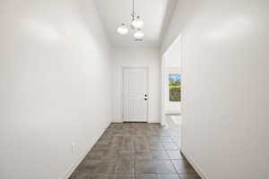 Corridor with a chandelier and baseboards