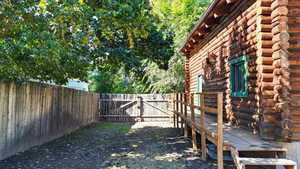 Fenced backyard featuring a gate and a wooden deck