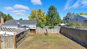 Fenced backyard with an outdoor structure, a gate, and exterior structure