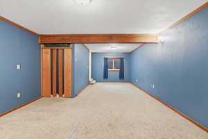 Finished below grade area featuring ornamental molding and carpet floors