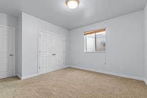 Unfurnished bedroom featuring carpet flooring, a closet, and a textured ceiling