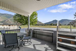 View of patio / terrace featuring a mountain view, a hot tub, and outdoor dining area