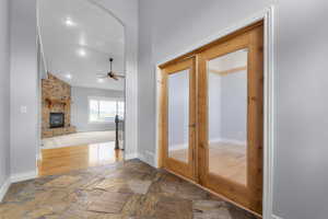 Corridor with stone tile floors, recessed lighting, and arched walkways