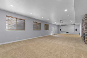 Cinema with recessed lighting, light carpet, and a textured ceiling