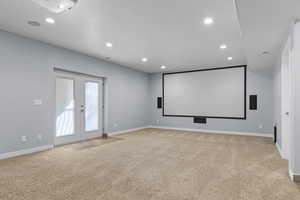 Home theater room with light colored carpet, french doors, recessed lighting, and a textured ceiling