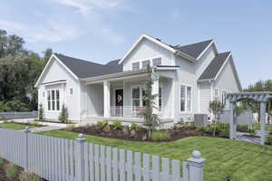 View of side of home featuring a fenced front yard, board and batten siding, a porch, and a shingled roof