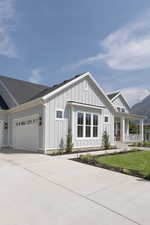 Modern farmhouse style home with board and batten siding, concrete driveway, covered porch, and a garage