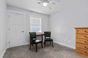 Living area with carpet, a desk, and ceiling fan