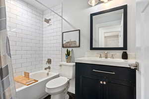 Bathroom with shower / bath combo with shower curtain and vanity