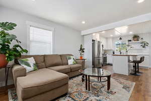 Living area with light wood-style vinyl flooring and recessed lighting
