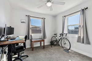 Home office with light colored carpet, plenty of natural light, and a ceiling fan