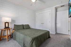 Bedroom with carpet floors, a closet, and a ceiling fan
