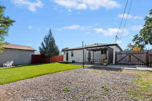 Back of property featuring a patio area, a fenced backyard, and a gate