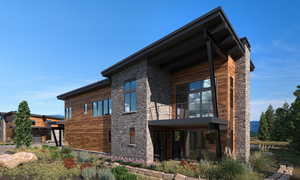 View of home's exterior with stone siding and a balcony - rendering
