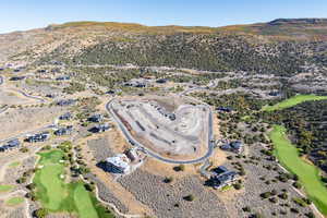 Aerial view of property's location featuring a mountainous background and a local golf course