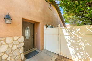 Doorway to property with a gate and stucco siding