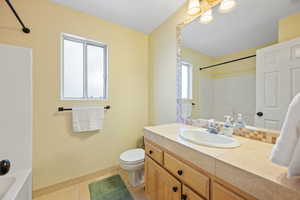 Full bath featuring vanity, washtub / shower combination, and light tile patterned flooring