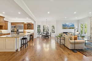 Living area featuring ornamental molding, recessed lighting, light wood-style flooring, and a chandelier