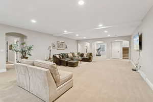 Downstairs rec room / living area with arched walkways, stairs, recessed lighting, and wet bar with two wine coolers, and bread warming drawer