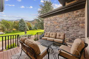 Deck with an outdoor hangout area, outdoor dining space, a lawn, and a mountain view