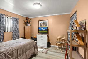 Bedroom featuring a textured ceiling and light wood finished floors
