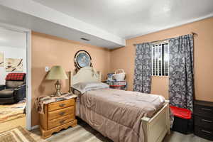 Bedroom featuring a textured ceiling and light wood-style flooring
