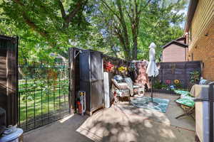Fenced backyard featuring a patio and view of wooded area