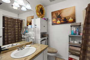 Bathroom with vanity, light tile patterned floors, and curtained shower