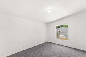 Spare room with lofted ceiling and carpet floors