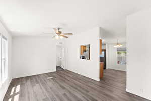 Unfurnished living room featuring wood finished floors, a chandelier, ceiling fan, and crown molding