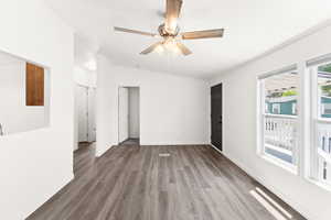 Spare room featuring ornamental molding, wood finished floors, a ceiling fan, and lofted ceiling