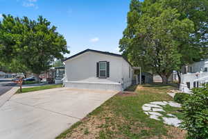 View of side of home featuring a yard and driveway